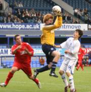 Two footballers compete for the ball in a schools cup final