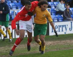 Two footballers competing for possession of the football