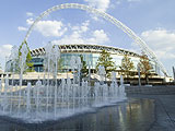 Photograph of public fountains in foreground and Wembley Stadium in the distance