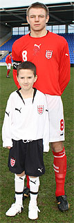 Photo of an England Schoolboy player with Mascot standing in front of him