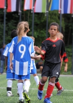 Boys and girls playing football together